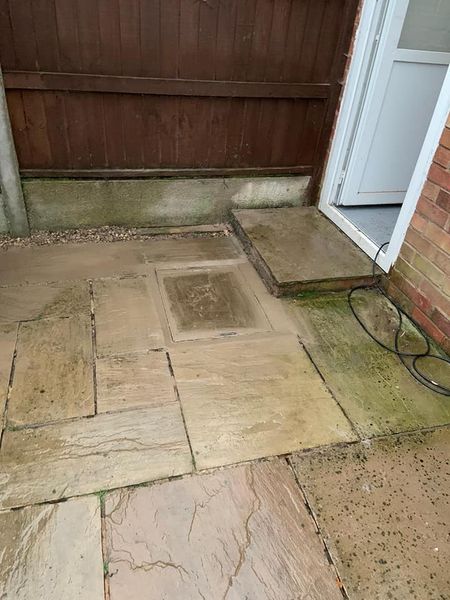 a stone patio with a door and a fence