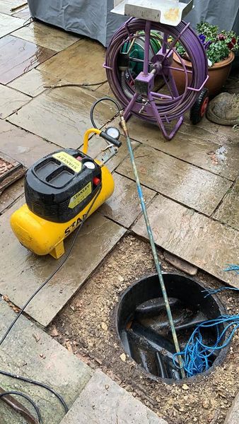 a yellow and black machine next to a black bucket